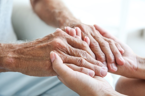 Young woman holding senior man hands, closeup